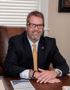 Robert E. Campbell, attorney profile sitting a desk.