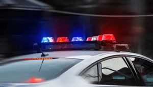 A police car flashing red lights on a street.