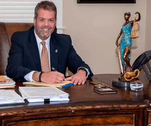 Robert Campbell sitting at a desk with pad and paper on it.